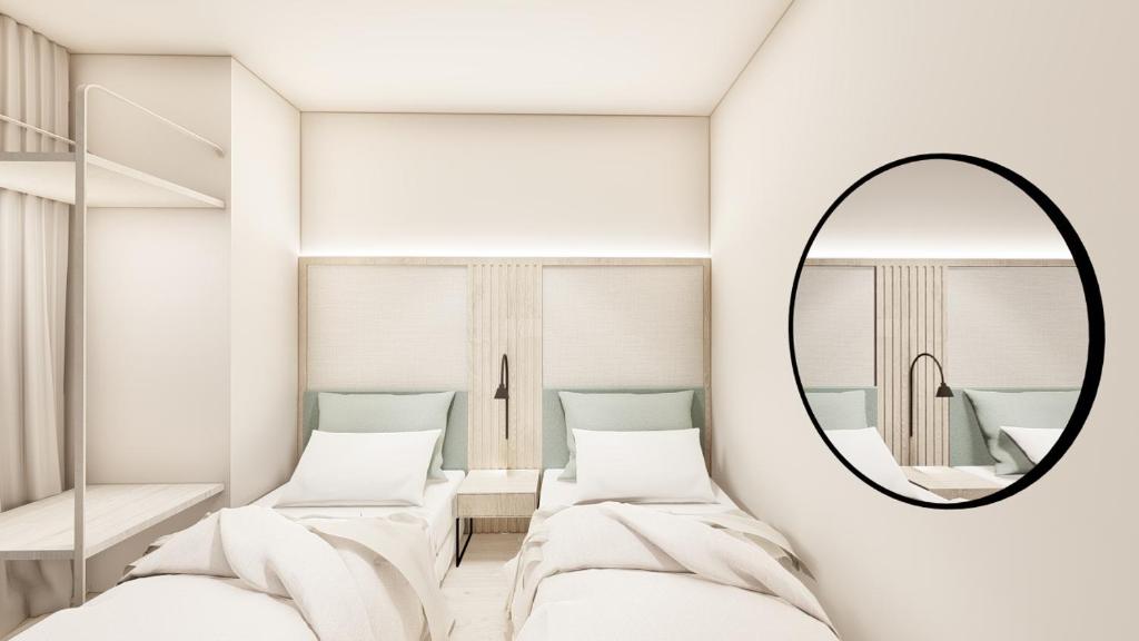 ベニドルムにあるDynastic Rooms Apartmentsの鏡付きの部屋のベッド2台