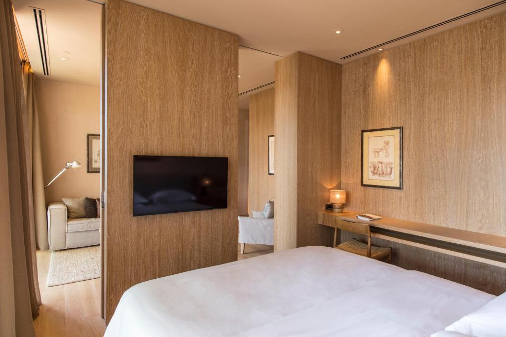 a hotel room with a bed and a flat screen tv at The Margi in Athens