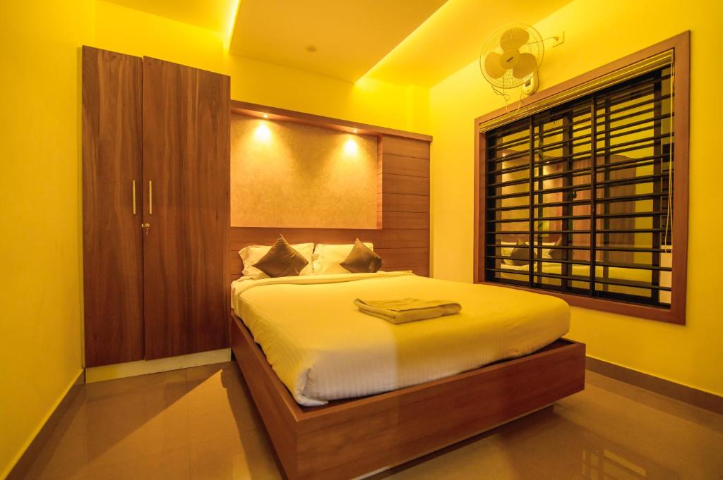 a bedroom with a large bed with a window at Rinad Castle Vythiri By Hamra Retreat in Vythiri