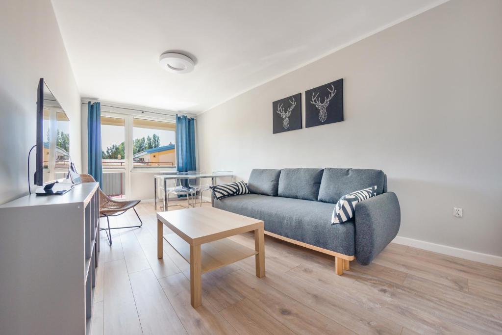 a living room with a couch and a table at Kopernika, Sun & Snow in Ustka