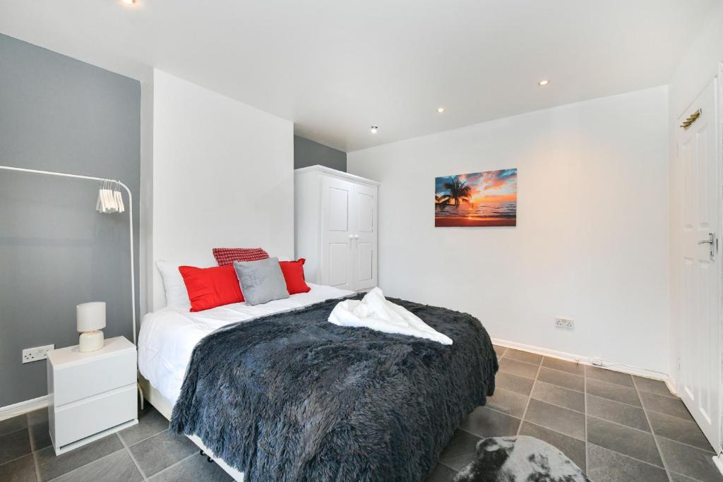 a bedroom with a large bed with red pillows at Impeccable 4-Bed House in Brixton London in London