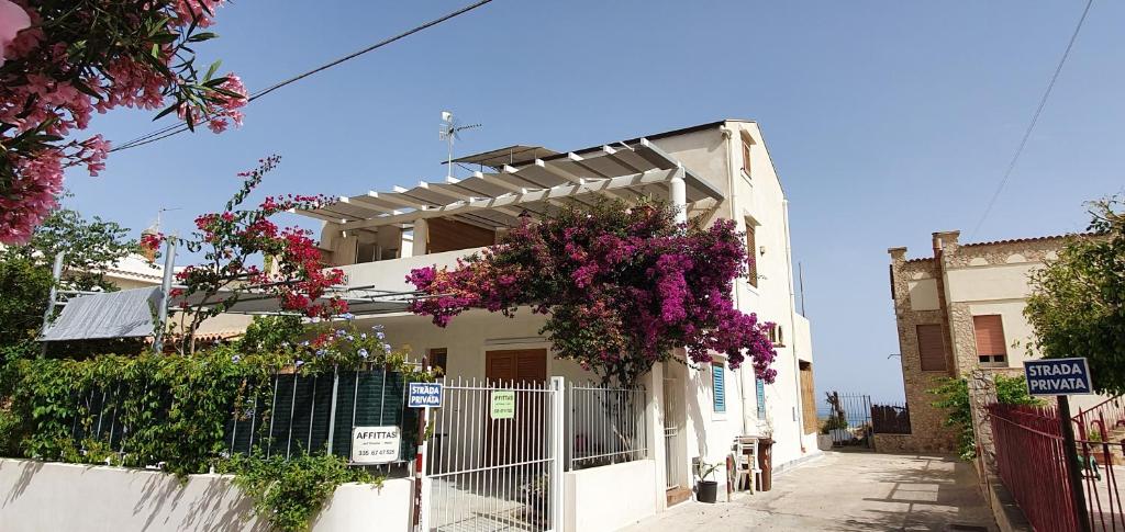 a white house with flowers on the side of it at Elios in Alcamo