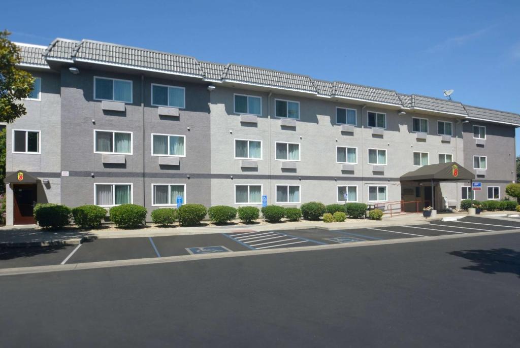 a large building with a parking lot in front of it at Super 8 by Wyndham Chico in Chico