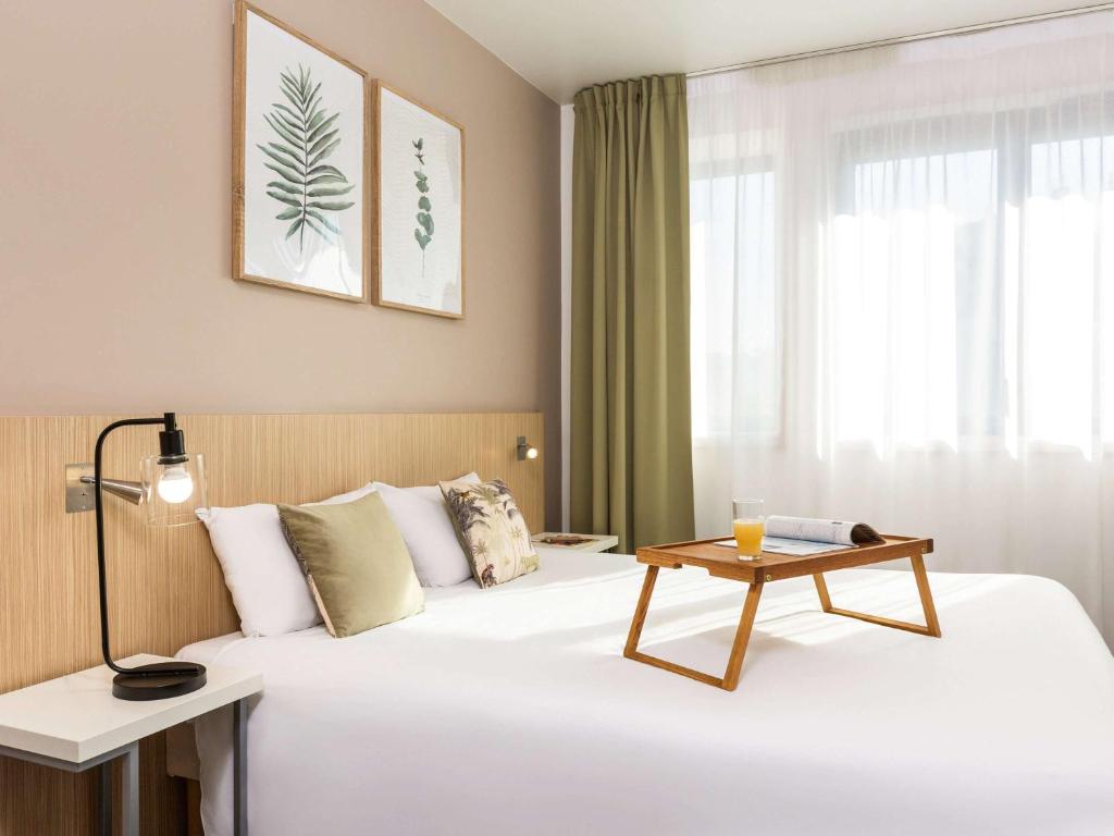 una habitación de hotel con una cama con una mesa encima en Aparthotel Adagio Access Paris Reuilly en París