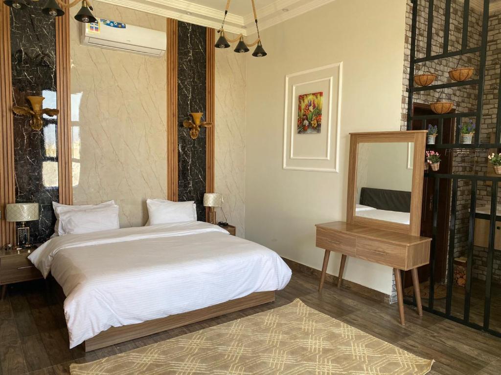 塞拉萊的住宿－Alnoor Mirbat，一间卧室配有一张床、镜子和一张桌子