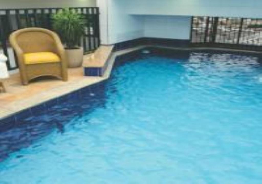 a large blue swimming pool with a chair in a building at Hotel Minas Tower in Leopoldina