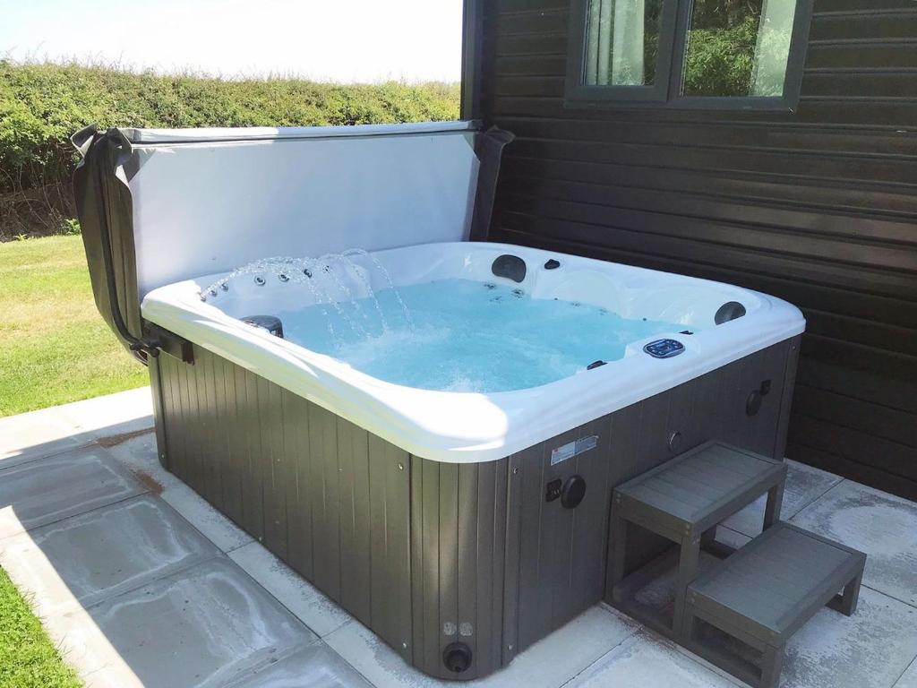a jacuzzi tub with a bench in a yard at King Richards Country Lodges in Earl Shilton