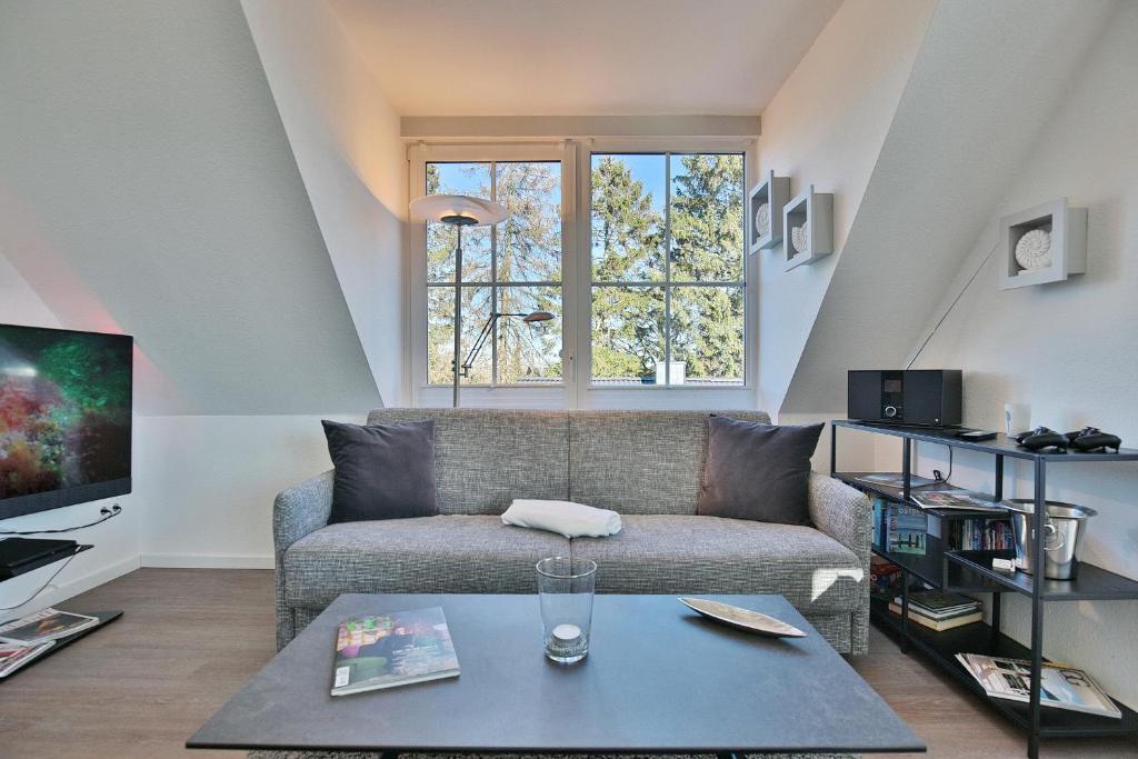 un soggiorno con divano e TV di Bädervilla Bergstraße 30 Bädervilla Bergstraße Appartement 9 a Timmendorfer Strand