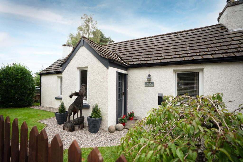 a statue of a horse in front of a house at Rose Cottage - Seasgair Lodges in Carrbridge