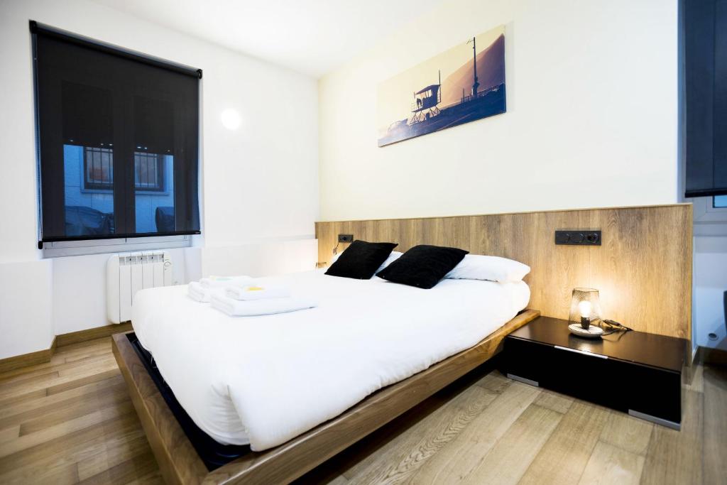 a bedroom with a large white bed and a large window at Bakea by Smiling Rentals in Hondarribia