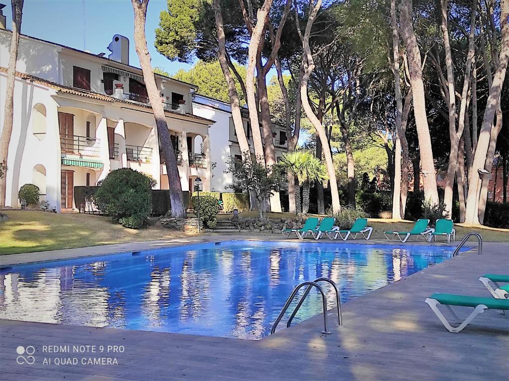 a swimming pool in front of a building at Apartamento Country Club 605 in Pals