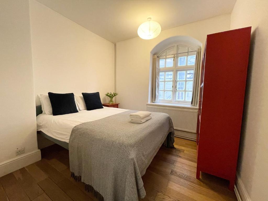 a bedroom with a bed and a red cabinet at Westminster Apartment near River Thames in London