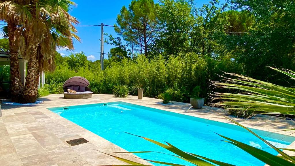 uma piscina no meio de um jardim em studio indépendant dans villa avec piscine jacuzzi em Vidauban