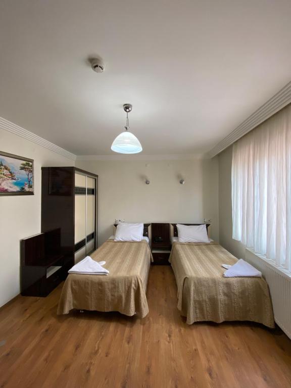 ein Hotelzimmer mit 2 Betten in einem Zimmer in der Unterkunft OTEL KING in Isparta