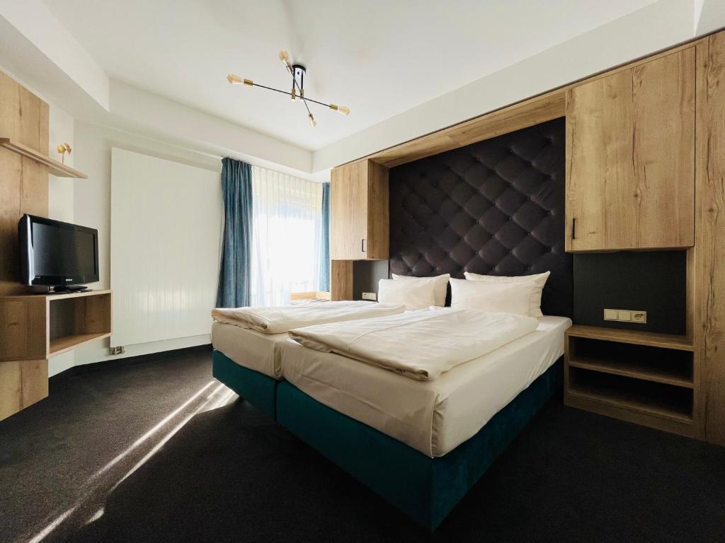 1 dormitorio con 1 cama grande y TV en Aparthotel Altes Dresden, en Dresden