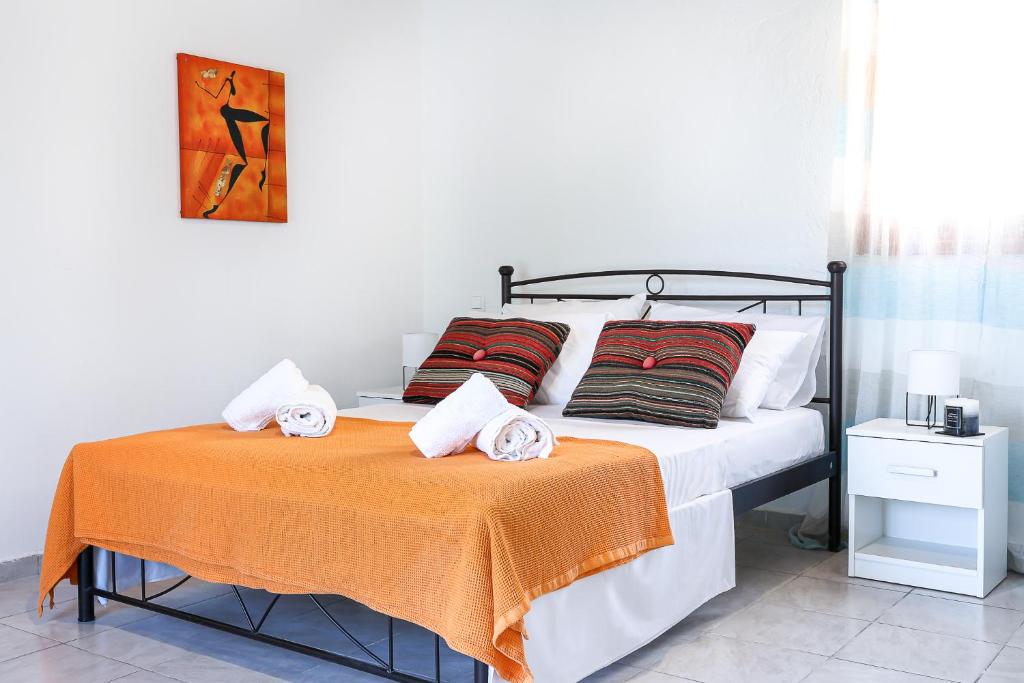 a bedroom with a bed with an orange blanket at Creta 2 bedrooms 6 persons village house in Vasilópoulon