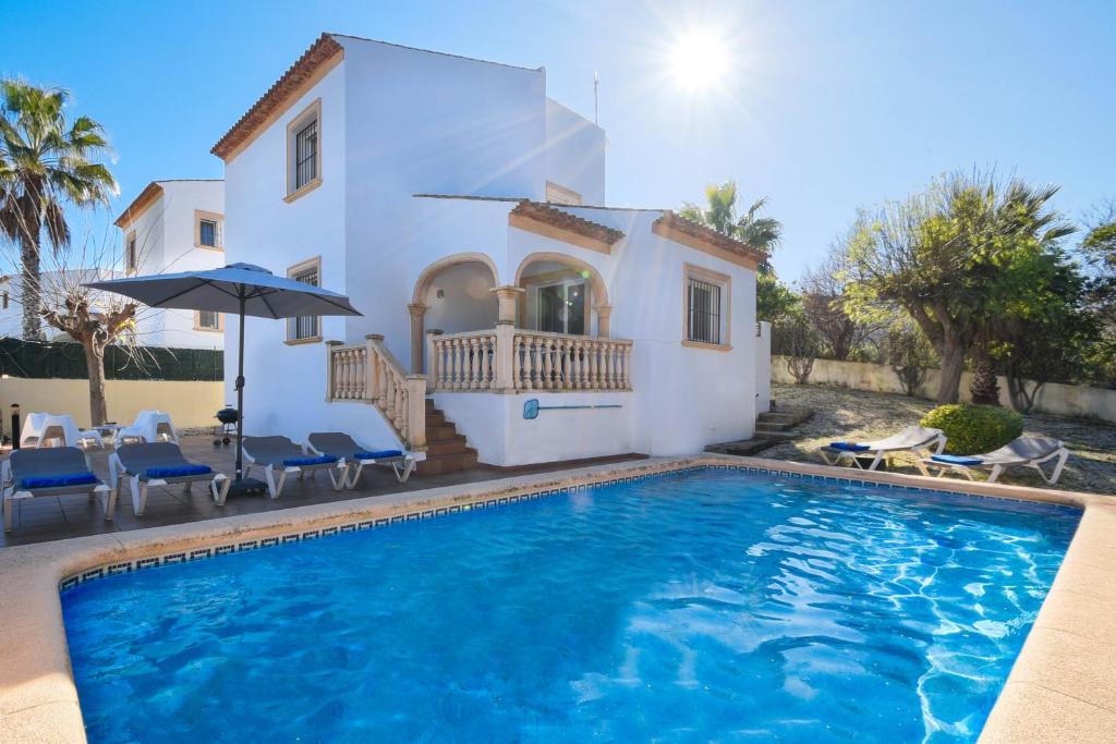 a villa with a swimming pool in front of a house at Monte Azul in Jávea