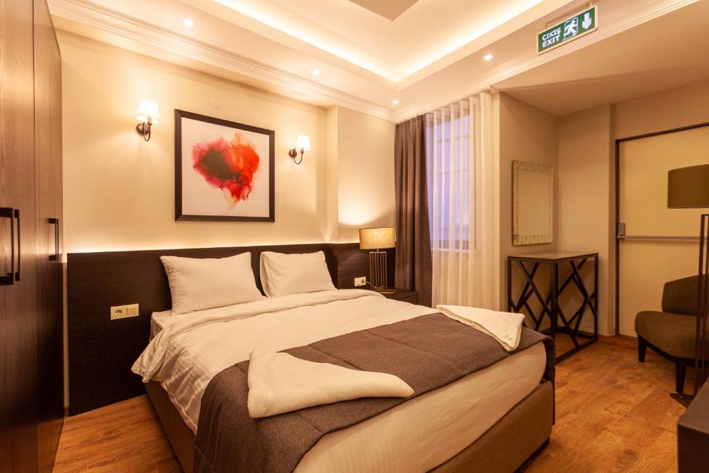 1 dormitorio con 1 cama grande y 1 silla en Lilium Luxury Suites en Estambul