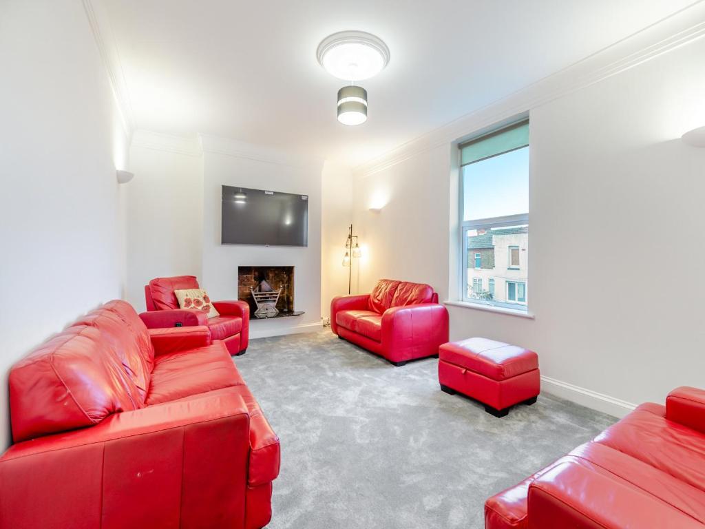 a living room with red furniture and a flat screen tv at Escape To Ramsgate in Ramsgate