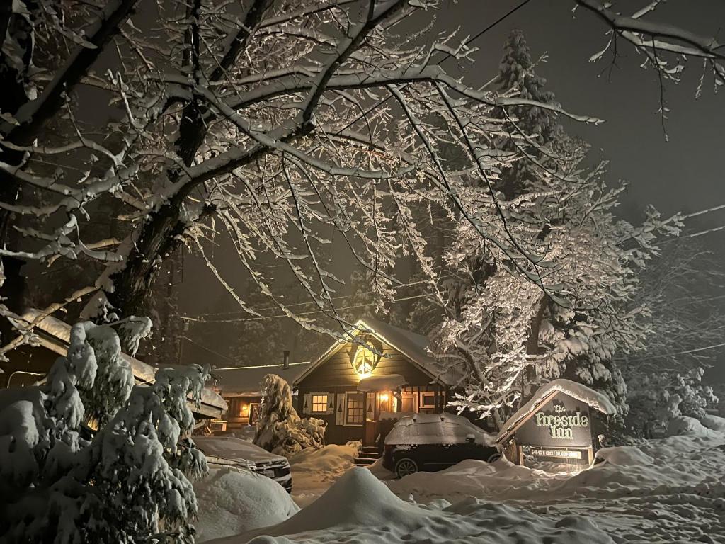 una casa cubierta de nieve por la noche en The Fireside Inn, en Idyllwild