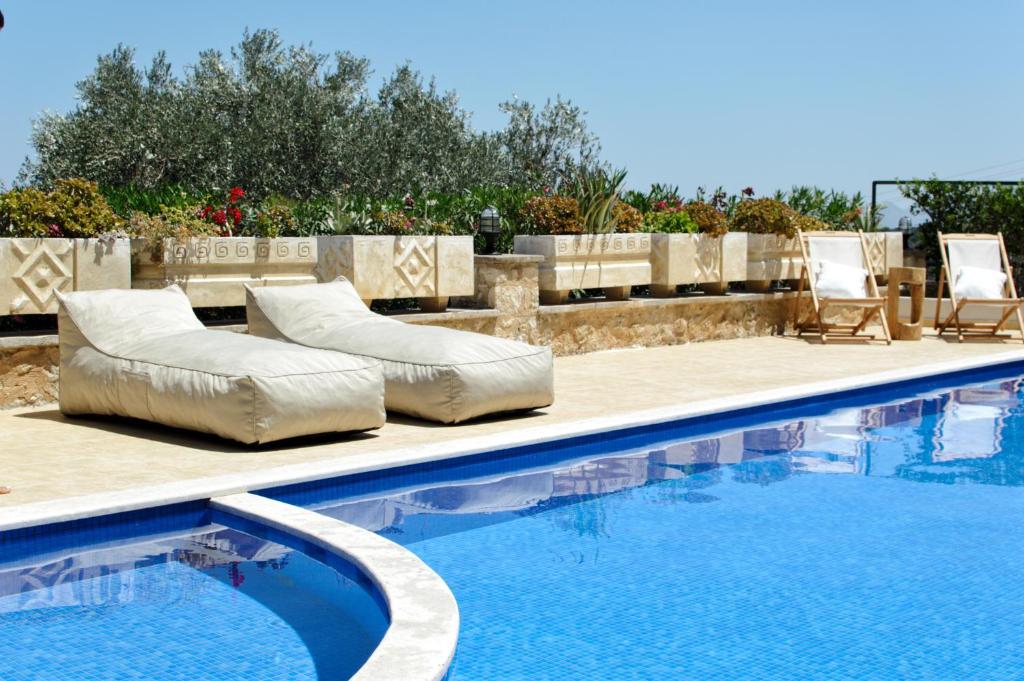 a swimming pool with two lounge chairs and a swimming pool at Luxury Villa Noesis with Pool and Seaview in Roussospítion
