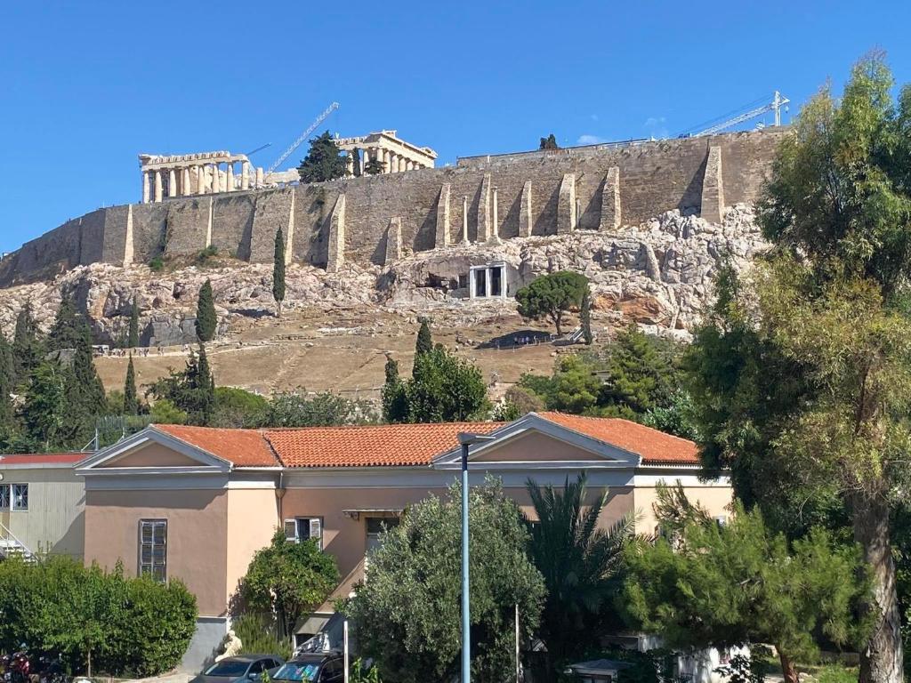 un edificio di fronte a una collina con l'acropoli di Check Point - Acropolis View ad Atene