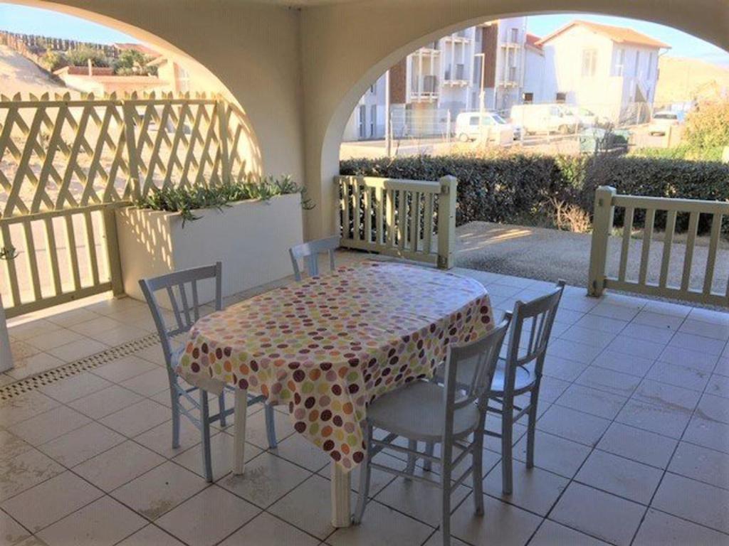 une table et des chaises assises sur un balcon avec une table et des chaises dans l'établissement Appartement T3 à 100m de l'océan avec terrasse, parking et animaux acceptés - Vieux-Boucau - FR-1-379-17, à Vieux-Boucau-les-Bains