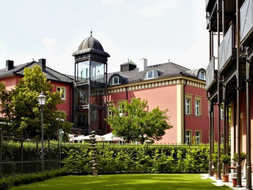 ein großes rotes Gebäude mit einem Uhrturm im Hintergrund in der Unterkunft Allee Hotel in Neustadt an der Aisch