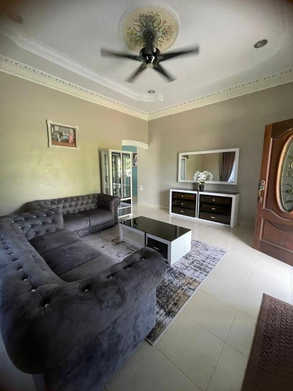 a living room with a couch and a ceiling fan at DnD Homestay in Kuala Berang