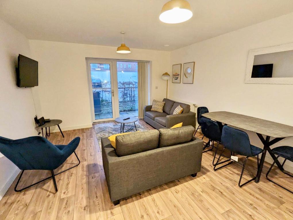 uma sala de estar com um sofá, uma mesa e cadeiras em Spacious 2 bed ground floor apartment, Free parking, close to Historic dockyard & Gunwharf Quays em Portsmouth