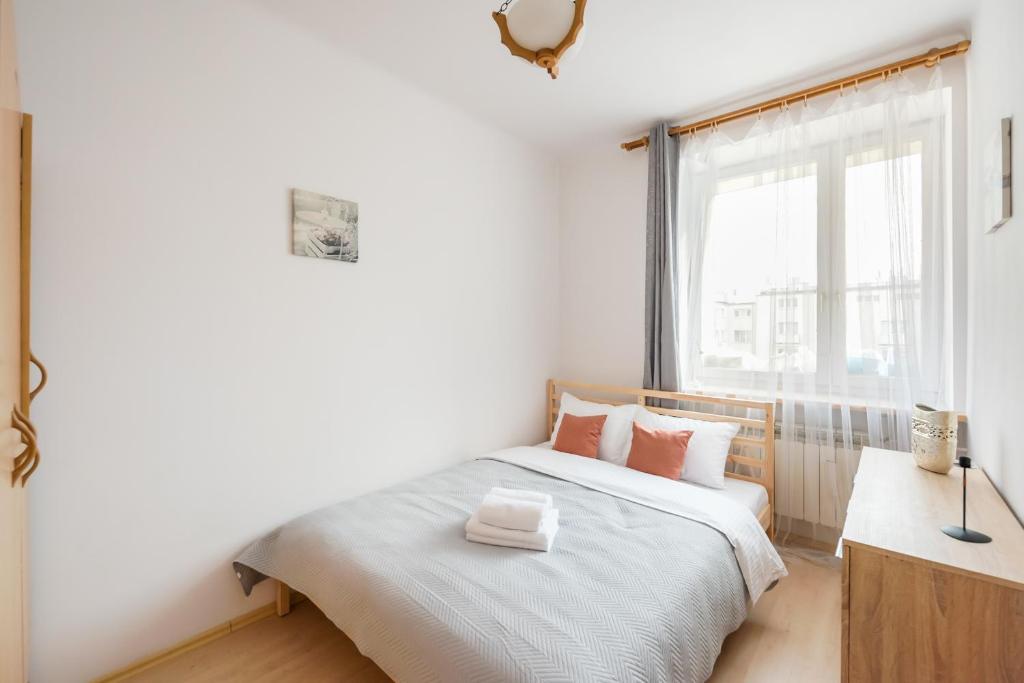 sypialnia z białym łóżkiem i oknem w obiekcie Plac Wilsona Euphony Apartment w Warszawie