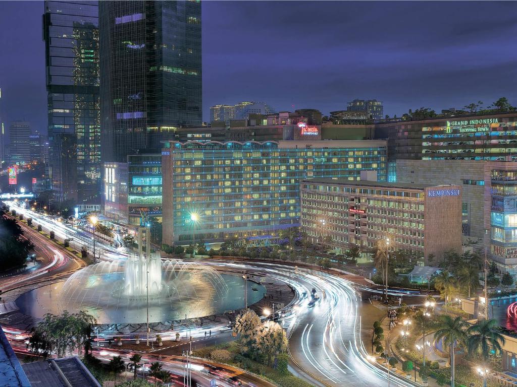 a city skyline at night with traffic and buildings at Hotel Indonesia Kempinski Jakarta in Jakarta