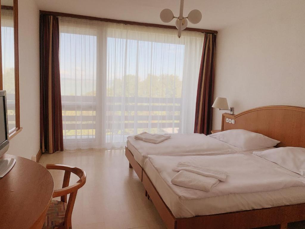 A bed or beds in a room at Riviera Park Hotel