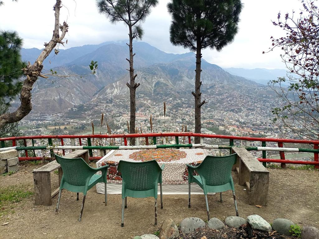 a table and chairs with a view of the mountains at Eagle Nest Cottage Muzaffarabad by LMC in Muzaffarabad
