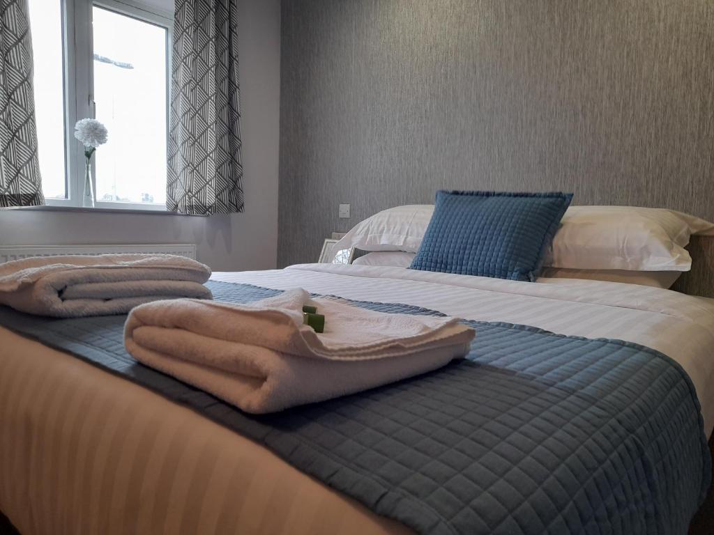 ein Schlafzimmer mit 2 Betten und Handtüchern darauf in der Unterkunft Apartments Heathrow - Hounslow in Cranford