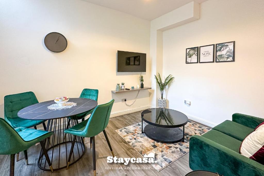 曼徹斯特的住宿－Stylish Ensuite Room - Superfast Wi-fi 250mbps，客厅配有桌椅和沙发