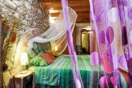 a bedroom with a bed with a mosquito net at Appartamenti Storici al Mare in Bosa