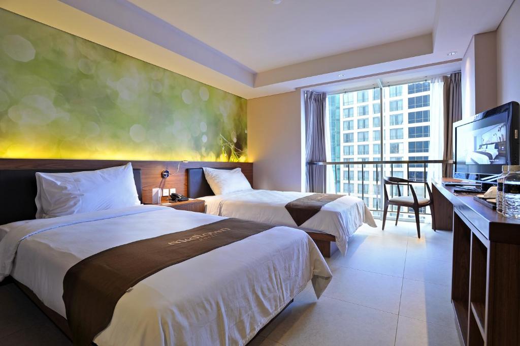 Tempat tidur dalam kamar di Midtown Hotel Surabaya