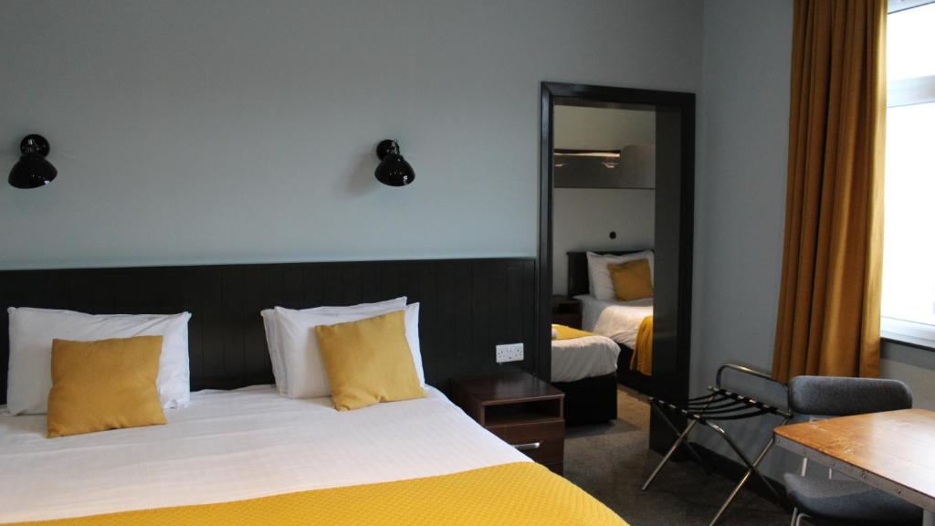 a hotel room with a bed and a mirror at Marine Hotel Ballycastle in Ballycastle
