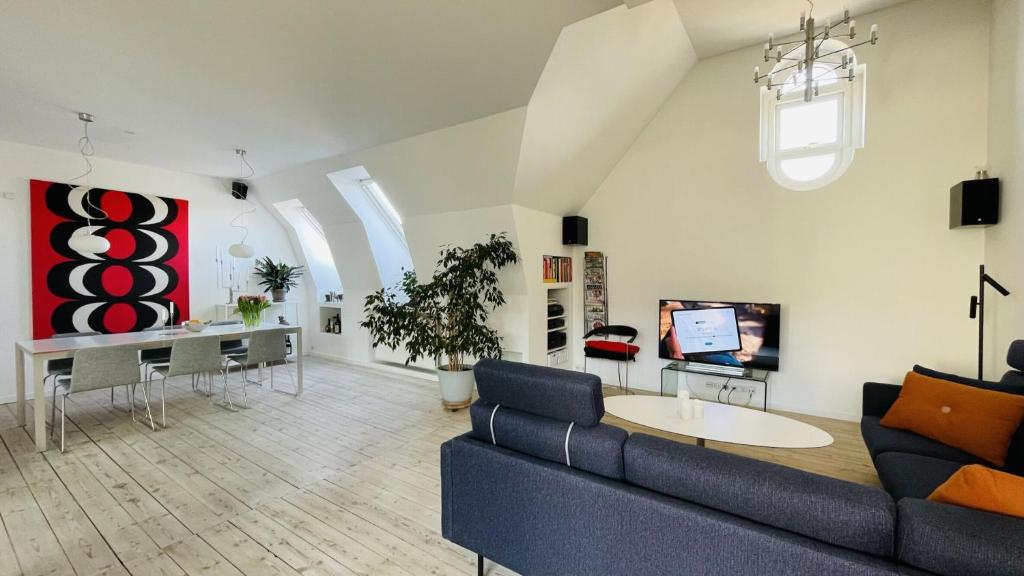 uma sala de estar com um sofá azul e uma televisão em ApartmentInCopenhagen Apartment 158 em Copenhague