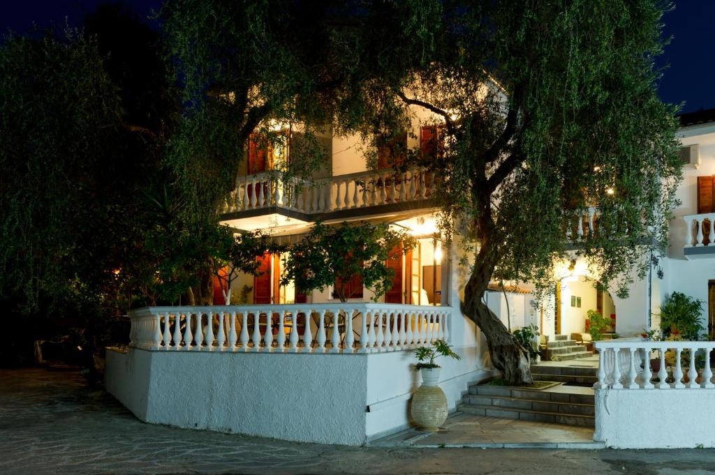een wit huis met een wit hek en een boom bij Pansion Nikos Vergos in Parga