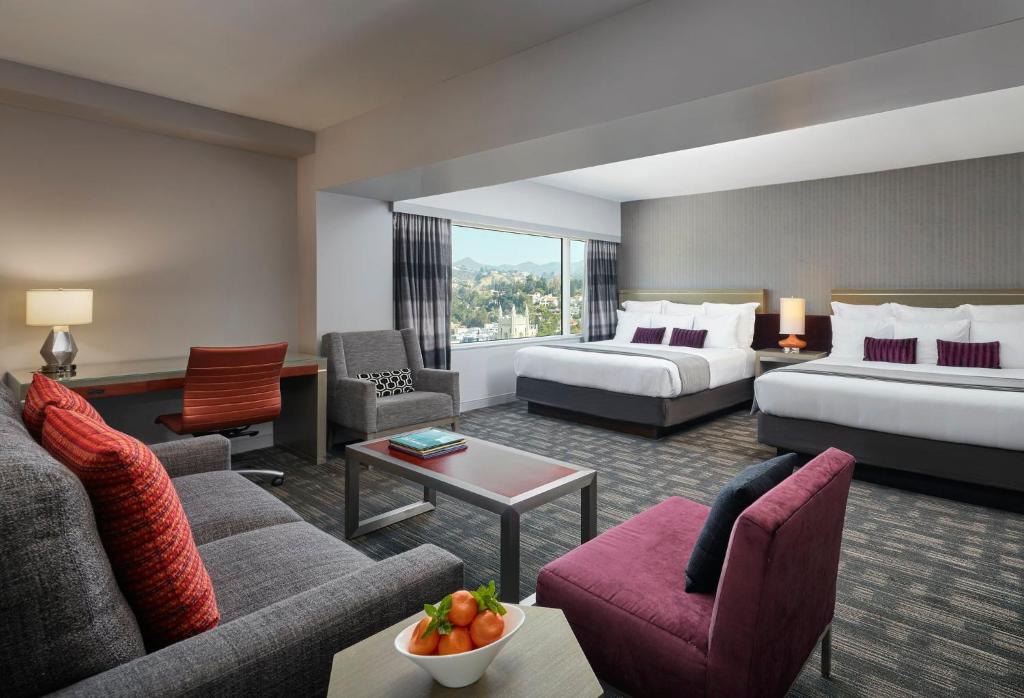 een hotelkamer met 2 bedden en een bank bij Loews Hollywood Hotel in Los Angeles