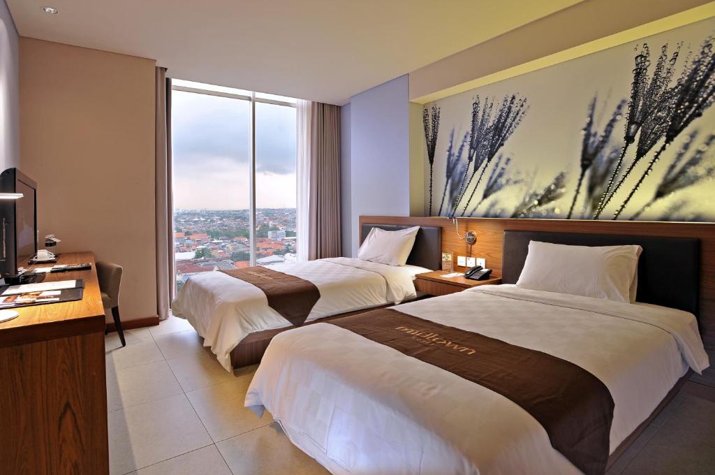 Postel nebo postele na pokoji v ubytování Midtown Hotel Surabaya