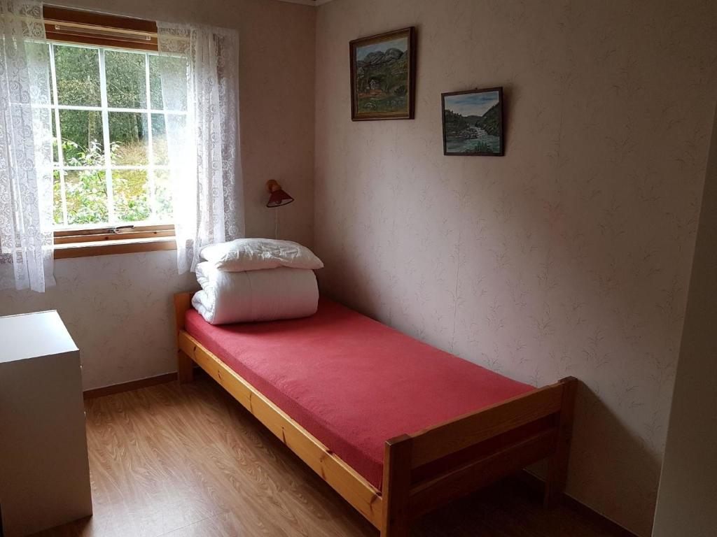 a small bedroom with a bed with a red mattress at Gepflegte Ferienhaus in der Region Ryfylke in Hebnes