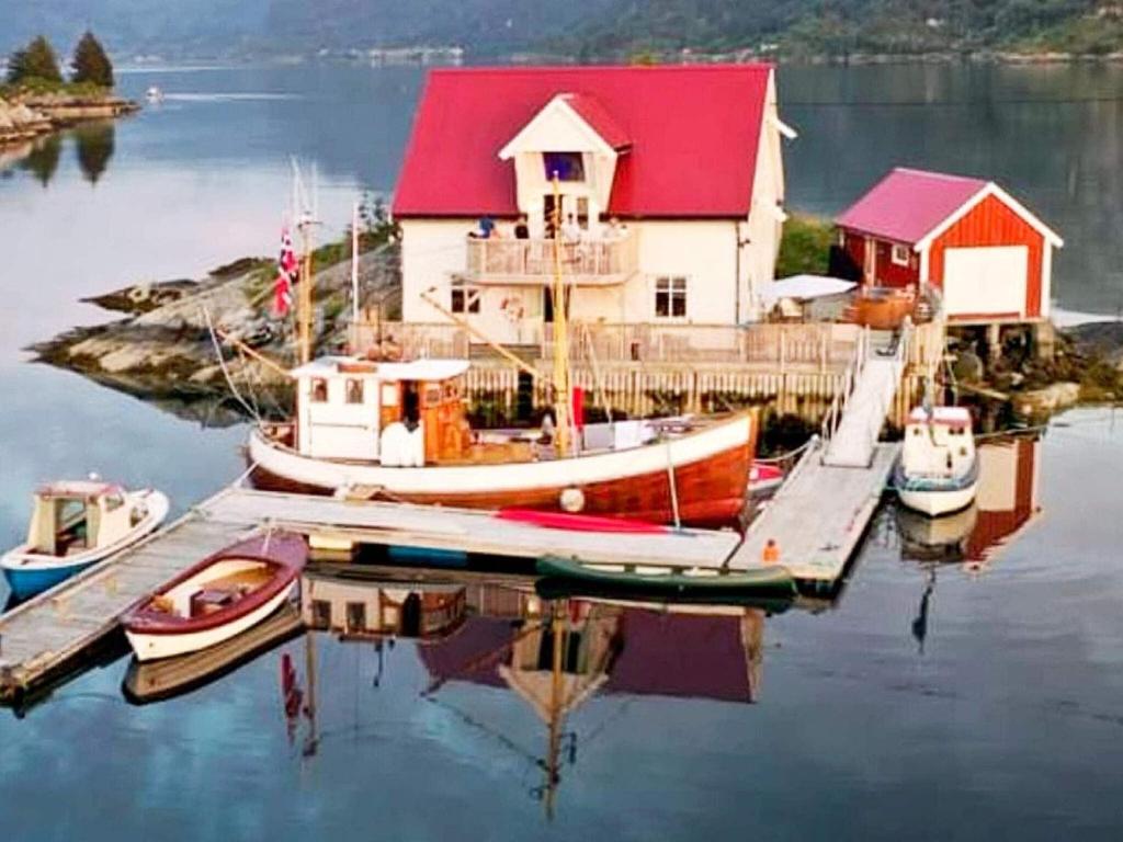 een huis met boten aangemeerd op een dok in het water bij Holiday home Flatraket IV 