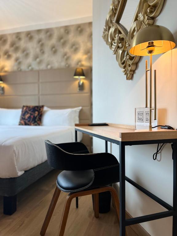 a bedroom with a bed and a desk with a chair at Hôtel La Villa Cannes in Cannes