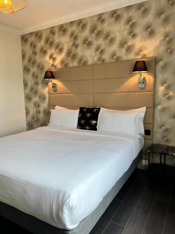 a bedroom with a large white bed with two lamps at Hôtel La Villa Cannes in Cannes
