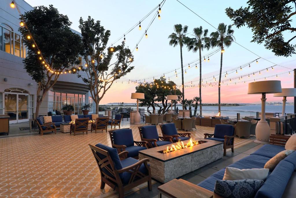 een patio met banken en stoelen en een vuurplaats bij Loews Coronado Bay Resort in San Diego