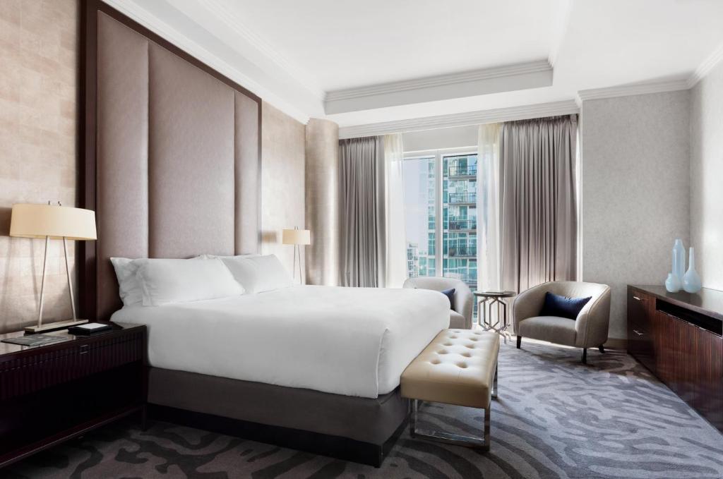 a bedroom with a large white bed and a chair at Loews Atlanta Hotel in Atlanta