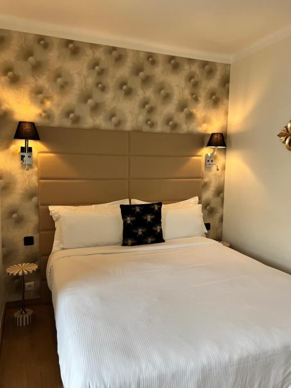 a bedroom with a large white bed with two lamps at Hôtel La Villa Cannes in Cannes